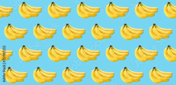Fototapeta a bunch of yellow bananas on a blue texture. lots of bananas on light texture