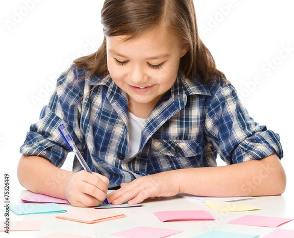 Fototapeta Girl is writing on color stickers using pen