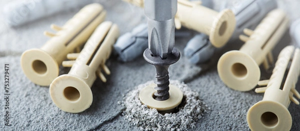Fototapeta screwdriver screw and dowel in a concrete wall background