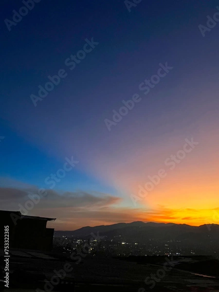 Obraz Colorful sunset with blue and orange sky. View of the city of Medellin.