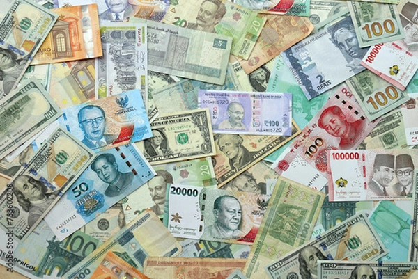 Obraz Many banknotes of different currency. Background of big amount of random money bills close up