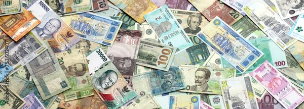 Obraz Many banknotes of different currency. Background of big amount of random money bills close up