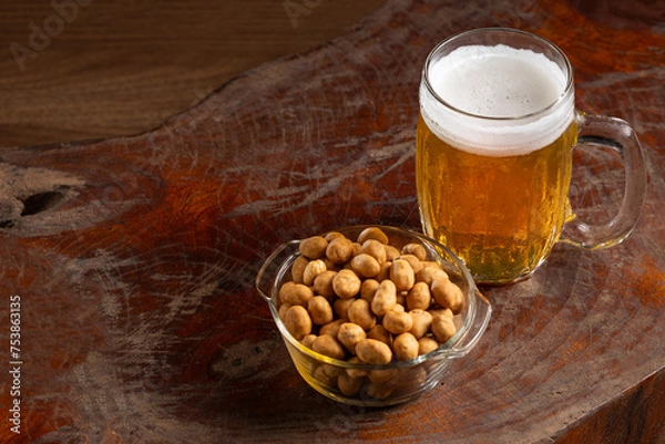 Fototapeta Glass of cold beer and peanuts on the table.