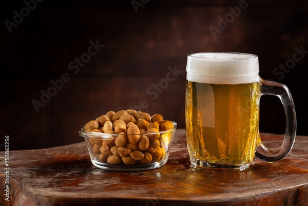 Fototapeta Glass of cold beer and peanuts on the table.