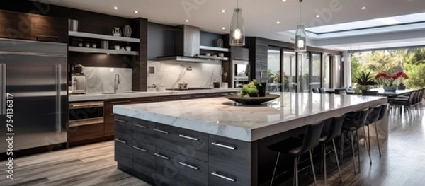 Fototapeta This modern luxury kitchen features a large center island, providing ample space for food preparation and casual dining. The island is equipped with a sink and built-in stove,