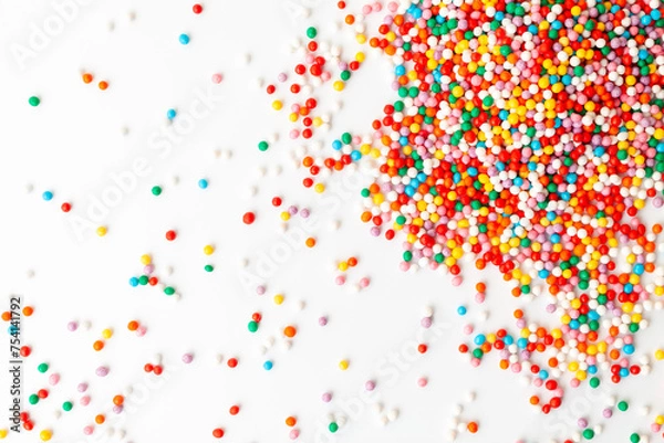 Fototapeta Colorful confectionery sprinkles on white background. Decoration for cake and bakery. Top view 