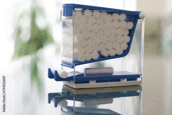 Obraz Blue Container Filled with White Cotton Balls on a Glassy Surface