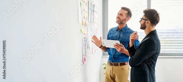 Fototapeta Panoramic picture of two colleagues planning business ideas at office