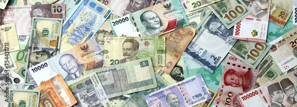 Obraz Many banknotes of different currency. Background of big amount of random money bills close up