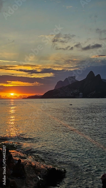 Fototapeta  Vertical shot of a sunset over Ipanema and Leblon beach taken from Arpoador in Rio de Janeiro.