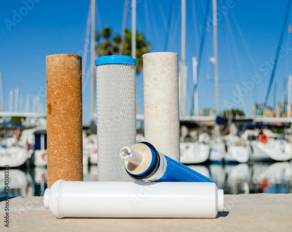Obraz A set of used cartridges for water purification. Filters and membranes for the reverse osmosis system on the yacht