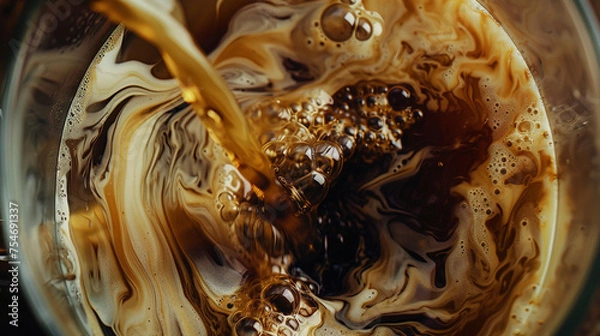Fototapeta Cold Brew Coffee Being Poured Into a Clear Glass with Milk - Artistic Swirl Effect Closeup with Liquids Mixing - In Tan, Beige, Brown, and Cream Color Tones