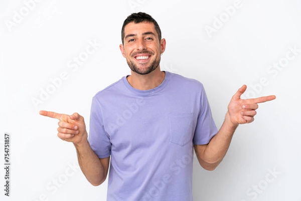 Fototapeta Young handsome caucasian man isolated on white background pointing finger to the laterals and happy
