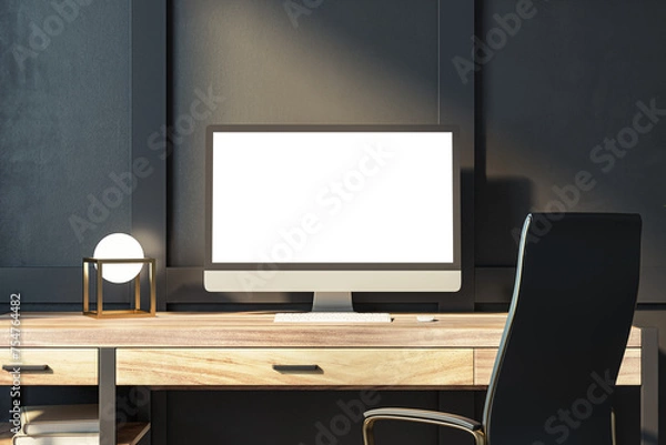 Fototapeta Stylish office setup with computer monitor, geometric lamp, and dark backdrop. Modern design concept. 3D Rendering