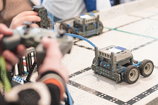 Fototapeta robot competitions, children control robots. High quality photo