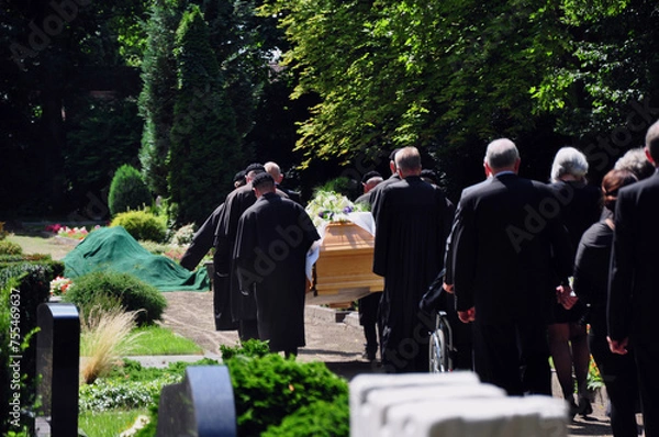 Fototapeta Beerdigung mit Trauerzug: Der Sarg wird von Trägern zur Grabstelle auf dem Friedhofsplatz getragen. 