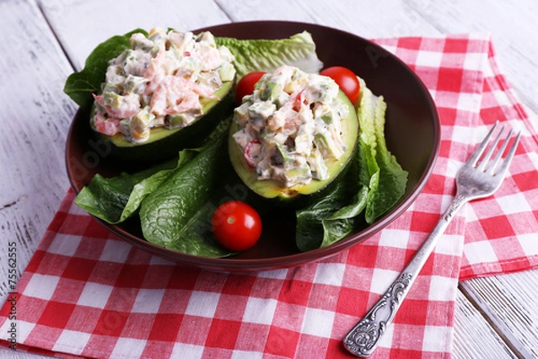Fototapeta Tasty salad in avocado on plate table close-up