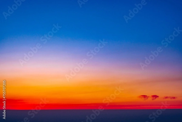 Fototapeta Spectacular sky with clouds at sunset as a background; the beginning of the blue hour after the sun sets below the horizon