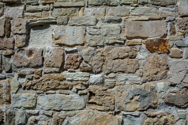 Fototapeta Close-up of a brown stone wall. Background image with copy space