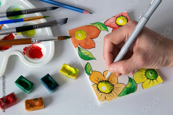Fototapeta handmade postcard with flowers using watercolor paints, brushes and liner, top view