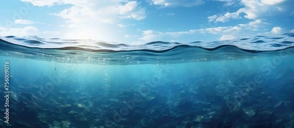 Fototapeta The electric blue sky reflects on the aqua water, creating a mesmerizing natural landscape with wind waves and cumulus clouds on the horizon