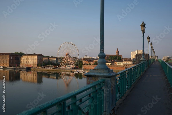 Obraz Tranquil morning scene at Pont Saint-Pierre Bridge in Toulouse, France. Historic bridge spans Garonne River, offering scenic views of skyline and iconic Ferris wheel reflections.