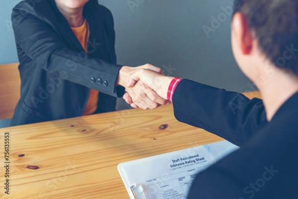 Fototapeta Business people job interview by HR officer shaking hands in office smiling face with happiness. Manager Businesswoman interview employee face to face sitting in meeting room. Job Interview Concept.