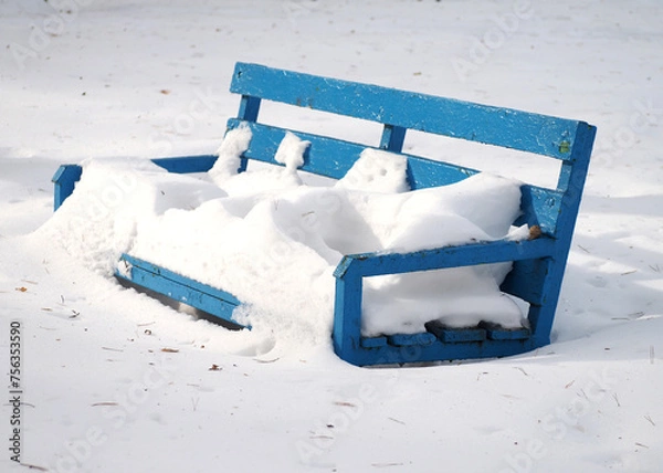 Obraz Winter background .Blue wooden bench covered with snow in the park.