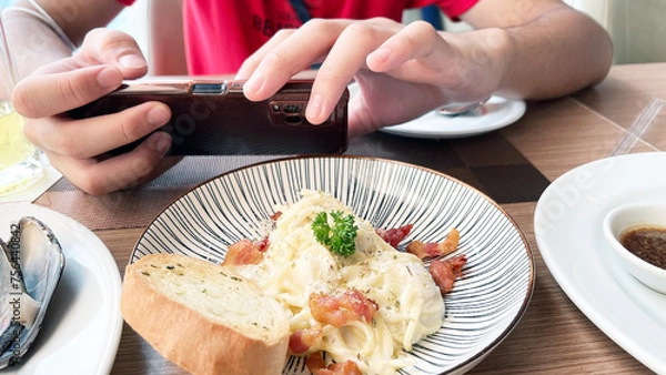 Fototapeta spaghetti carbonara, focusing on the hand taking a shot 