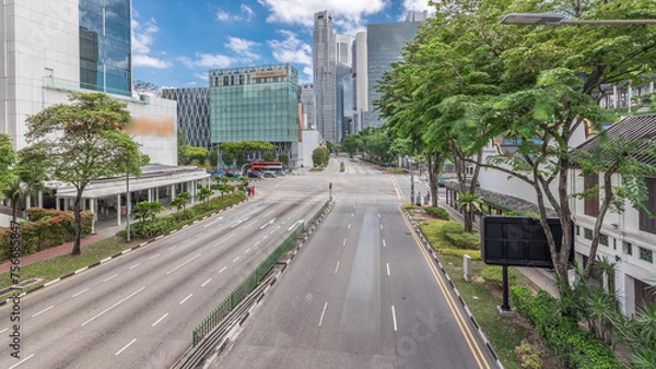 Fototapeta Traffic with cars on a street and urban scene in the central district of Singapore timelapse