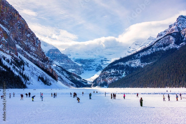 Obraz Visitors skating on frozen Lake Louise in Winter against the backdrop of the stunning Victoria Glacier