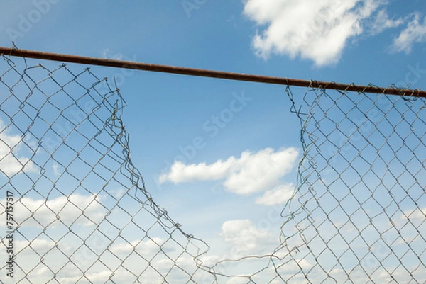 Fototapeta Broken metal mesh fence