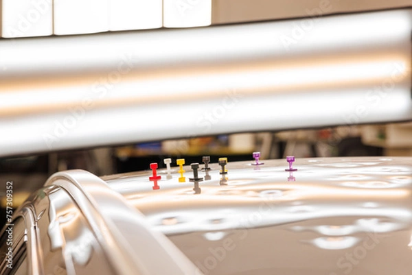 Fototapeta Close up of car adorned with pins, dent removal after hail