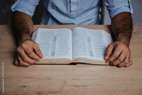 Fototapeta Man is ready to read the bible in a low light environment