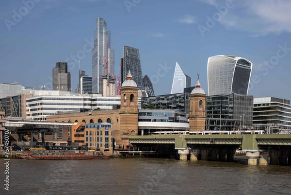 Fototapeta Cityscape of the city of London including Cannon Street Railway Station and Bridge taken from over the river Thames