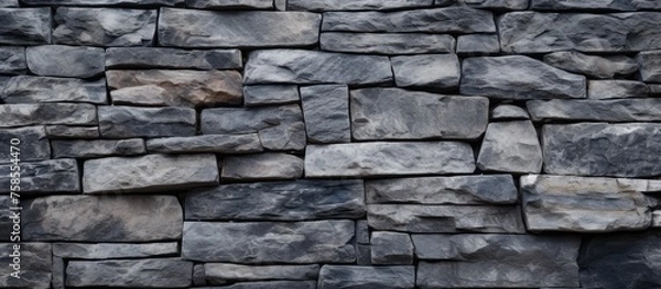 Fototapeta Closeup of a stone wall made of rectangular bricks, showcasing a beautiful pattern of brickwork and mortar. The composite material provides a sturdy and classic look to the building