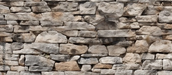 Fototapeta A detailed shot of a stone wall showcasing a variety of rocks, showcasing the natural beauty and durability of this composite building material