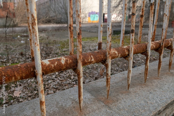 Fototapeta old rusty fence, with signs of age and neglect, work to remove the rust, and apply anti-rust and new paint