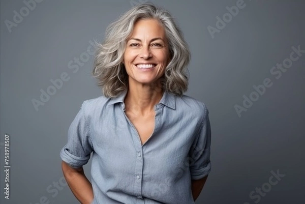 Obraz Portrait of a happy senior woman with grey hair over grey background