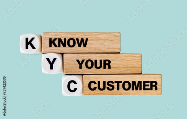 Fototapeta A stack of wooden blocks arranged in a tower that say word text acronym KYC KNOW YOUR CUSTOMER 