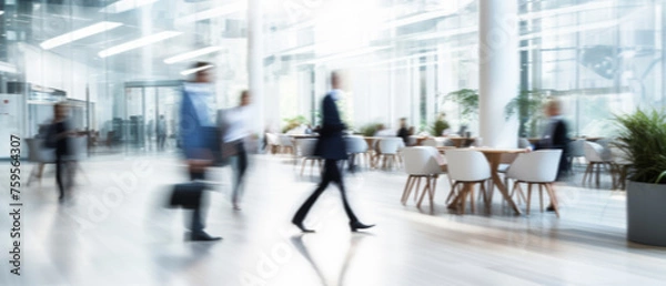 Obraz Business people walk in a large office lobby against a cityscape background. Motion blur effect, bright business workplace with people in walking in blurred motion in modern office space