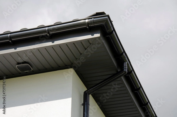 Fototapeta Plastic gutter system on a house with security system