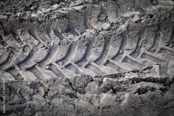 Fototapeta Tractor wheels imprint in raw soil. Textured abstract background