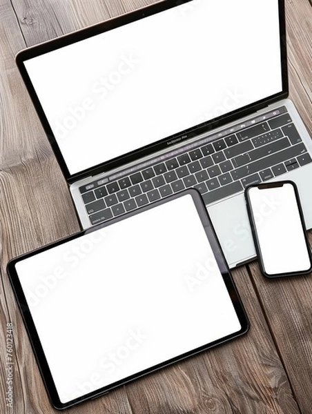 Fototapeta Open laptop with digital tablet and white smartphone. All with isolated screen on old wooden desk.