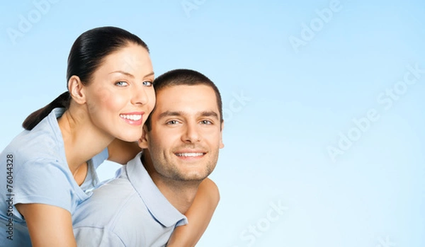 Fototapeta Cheerful young couple, over blue