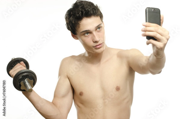 Fototapeta Skinny man taking selfie with phone while training biceps