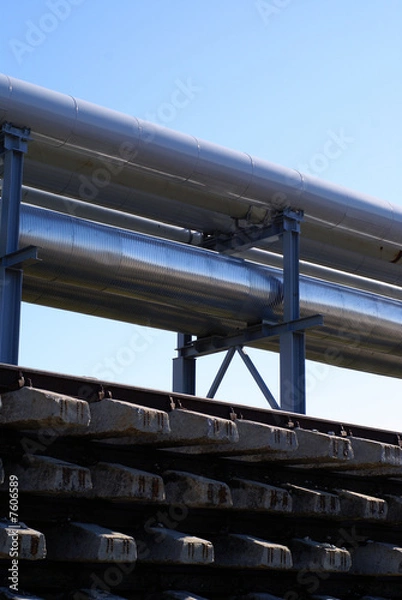 Fototapeta industrial pipelines on pipe-bridge against blue sky