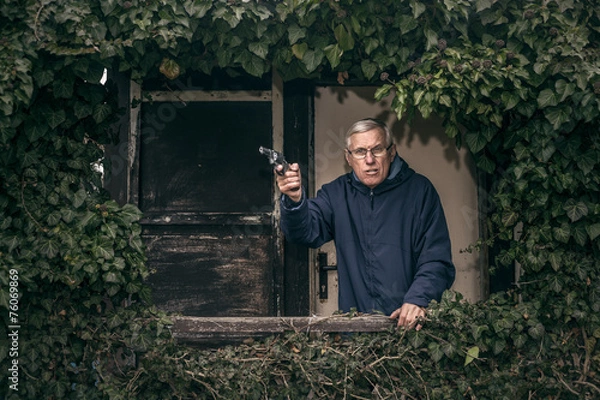 Fototapeta Senior man with a gun protecting property