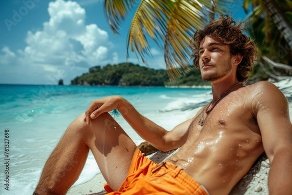 Fototapeta A man relaxing on a sandy beach next to a tall palm tree under the bright sun.