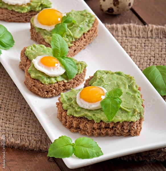 Fototapeta Sandwich with avocado paste and egg in the shape of heart